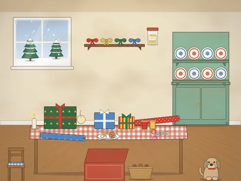 A kitchen table covered in present wrapping: rolls of patterned paper, wrapped parcels with bows, ribbon spools, gift tags, a roll of sticky tape and scissors, a plate of mince pies, a candle, a dresser of plates, a window with snow and a dog under the table.